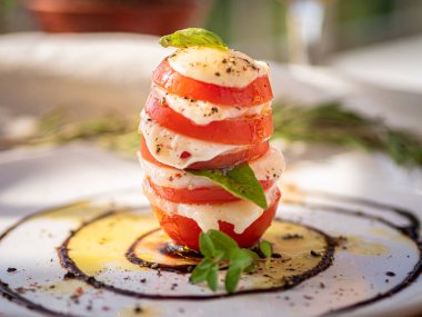 Tahta tabakta çeşitli peynir atıştırmalıkları ve beyaz tabakta salata.