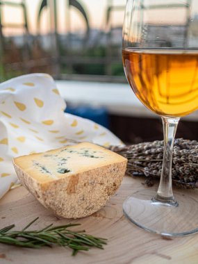 Tahta tabakta çeşitli peynir atıştırmalıkları ve beyaz tabakta salata.