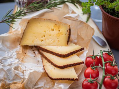 Tahta tabakta çeşitli peynir atıştırmalıkları ve beyaz tabakta salata.