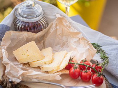 Tahta tabakta çeşitli peynir atıştırmalıkları ve beyaz tabakta salata.