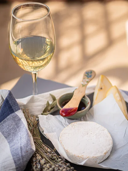 Tahta tabakta çeşitli peynir atıştırmalıkları ve beyaz tabakta salata.