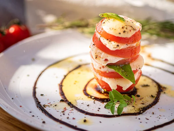 Tahta tabakta çeşitli peynir atıştırmalıkları ve beyaz tabakta salata.