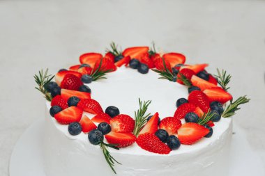 meyveler ve otlar ile dekore edilmiş beyaz pasta