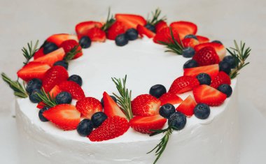 meyveler ve otlar ile dekore edilmiş beyaz pasta