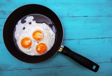 ahşap bir masa üzerinde sahanda yumurta