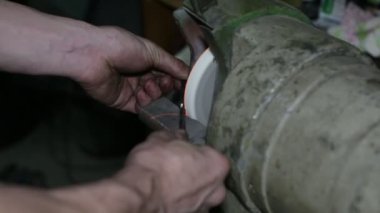 Öğütme taşı. Matkap bileme. Sanayi fabrikasında ki taşlama tekerleğinde metal matkap bileen adam. Bir metal işçisi elmas tekerleğin üzerindeki matkap parçasını biler..
