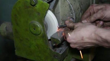 Öğütme taşı. Matkap bileme. Sanayi fabrikasında ki taşlama tekerleğinde metal matkap bileen adam. Bir metal işçisi elmas tekerleğin üzerindeki matkap parçasını biler..