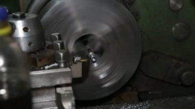 Torna iş başında. Geç gösteride eski deri. Makinenin operatörü eski bir deri üzerinde çalışır. Parça üretimi.