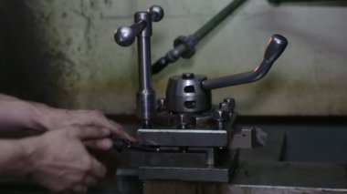 Torna iş başında. Torna dükkanında ki eski torna. Makinenin operatörü eski bir torna üzerinde çalışır. Torna nın ayarlanması