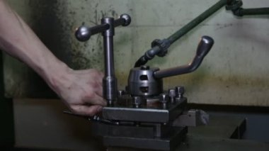 Torna iş başında. Torna dükkanında ki eski torna. Makinenin operatörü eski bir torna üzerinde çalışır. Torna nın ayarlanması
