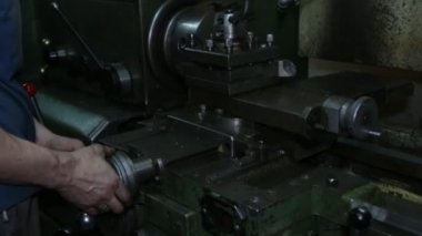 Torna iş başında. Torna dükkanında ki eski torna. Makinenin operatörü eski bir torna üzerinde çalışır. Torna nın ayarlanması