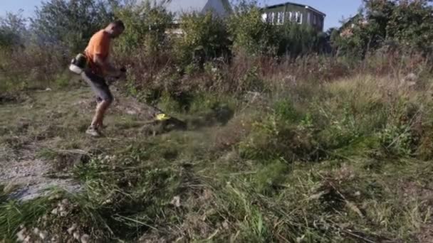 Man Klipper Gräset Med Gräsklippare Trimmer För Gräsklippning — Stockvideo