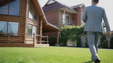 Takım elbiseli adam elinde bir buket ile çim yürüyor. Yakın çekim