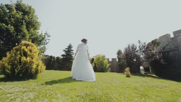エレガントな花嫁が歩く 城で回転します 戸外で歩く — ストック動画