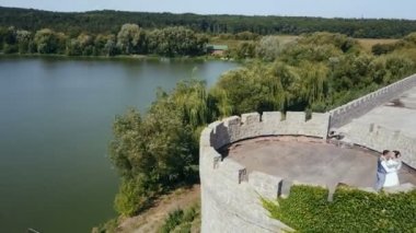Güzel romantik düğün çifti, damat ve gelin eski bir kale sarılma. Antik kaleler yok