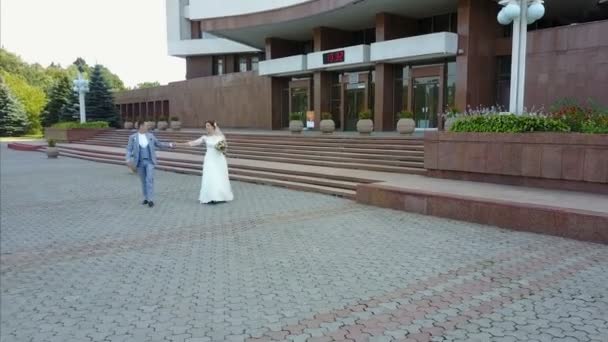 Encantadores Recién Casados Elegantes Están Tomados Mano Mientras Caminan Por — Vídeo de stock