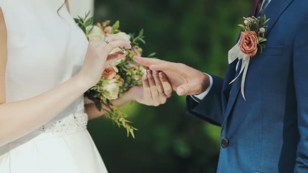 Recém Casados Trocam Anéis Cerimônia Casamento Sobre Fundo Grama Verde — Vídeo de Stock