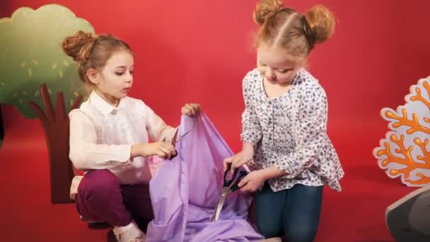 Kleine Meisjes Snijd Een Stuk Doek Met Een Schaar Studio — Stockvideo