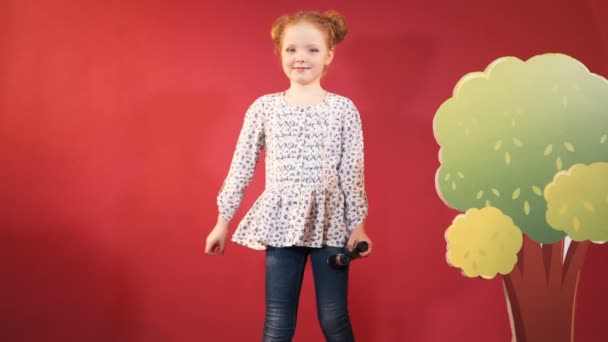 Маленькая Девочка Биноклем Руках Позирует Изолированный Красном Фоне — стоковое видео