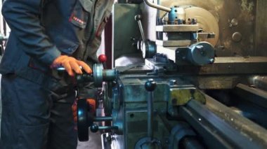 Genç makinist bir torna üzerinde çalışıyor. Metal işleme sanayi.