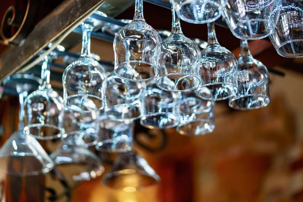 Glasses hanging over bar rack. Empty glasses for wine above a bar rack