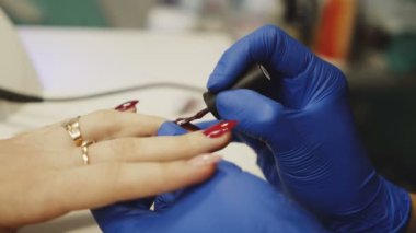 Manikür ustası çivi salonda kız için boyar. El bakım Spa.