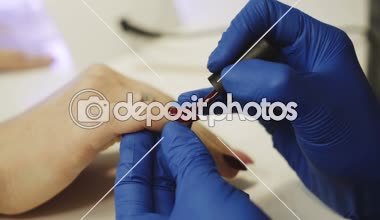 Spa salonda manikür yapmanın süreci. Şevval özçelik güzellik güzellik salonları çivi kırmızı tırnak cilası uygulayarak. El bakım kavramı.