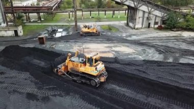Fabrikadaki kömür işleme operasyonları. Sürüngen buldozer çalışıyor. Hava görünümü.