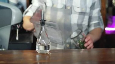 Barmen bir buz ile bir şeker kamışı ve lezzetli bir kokteyl yapmak için kireç kokteyl cam içine ekleme