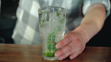 Bir kokteyl hazırlama işlemi. Kokteyl limon ve nane çubuğu mojito. Yakın çekim