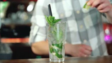 Barmen süsleyen hazır bir kokteyl barda duruyor kireç ile sayaç