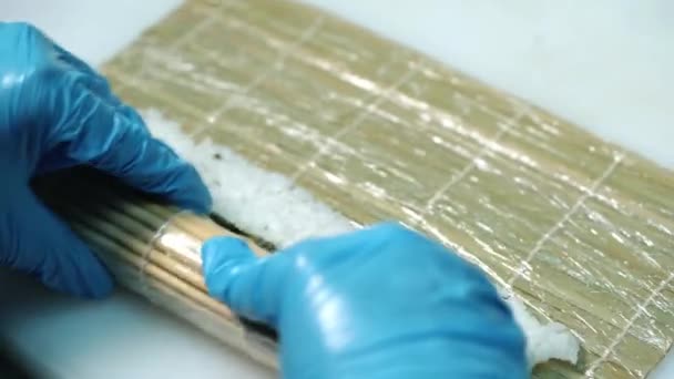 专业厨师手特写在海藻垫子上滚动寿司卷 — 图库视频影像