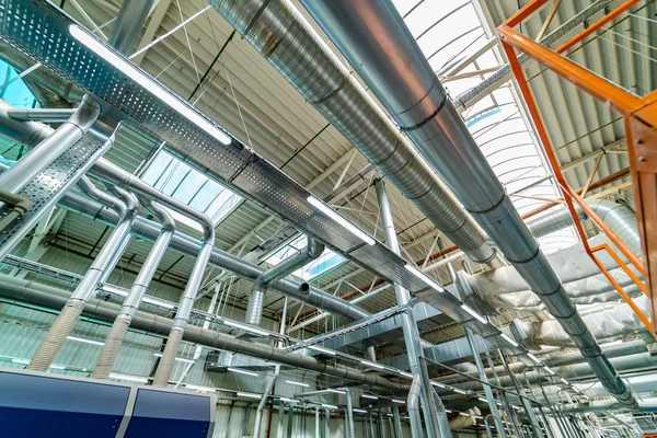 在新大楼内悬挂在天花板上的银绝缘材料的通风管道 现代工业工厂 — 图库照片