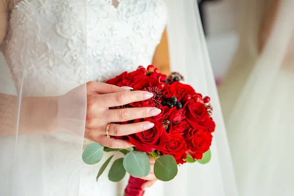 Bouquet in the hands of the bride. Wedding bouquet of red roses.