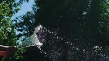 Kauçuk hortum dan temiz su akışı. Yaz bahçe. Ağır çekim.