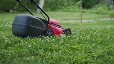bahçede çim biçme makinesi ile çalışan küçük çocuk