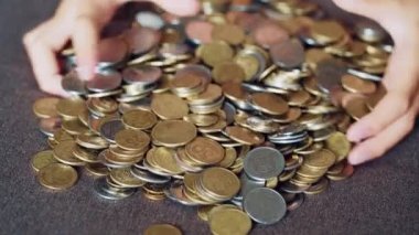Çocuk madeni paralarla oynuyor. Büyük para sikke yığını