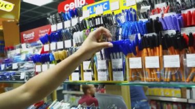 Vinnitsa, Ukrayna - 20 Ağustos 2018: Satınalma depodaki örneği. Kadın eli bir kalem seçer.