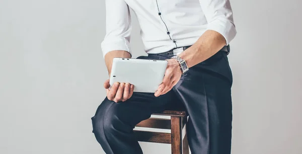 Człowiek Posiada Tablet Jego Ręce Białym Tle Siedzi Krześle Ubrana — Zdjęcie stockowe