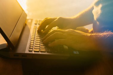 bir adam Nehri yakınında gün batımında diz üstü klavyede metin türleri. İş ile meşgul adam