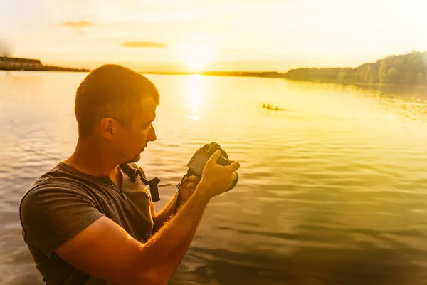 Homem Olha Para Fotos Câmara Perto Rio Pôr Sol Cara — Fotografia de Stock