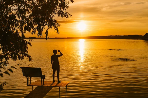 Muž Stojí Zdiva Poblíž Jezera Dívá Západ Slunce Lidé Koupat — Stock fotografie