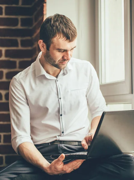 사업가 가까이 사무실에서 자신의 노트북에 비즈니스를 읽는다 — 스톡 사진