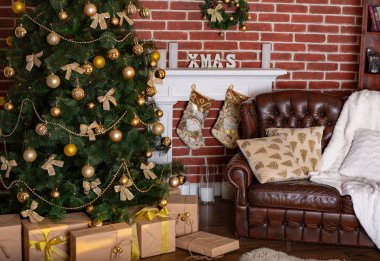 dekoratif bir şömine ve hediyeler Noel ağacı ve odadaki yastıklar ile deri koltuk altında güzel konumu
