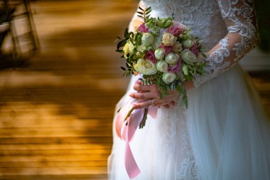 Lüks beyaz dantel elbise gelin gül buketi oda onun elinde tutar. Yakın çekim