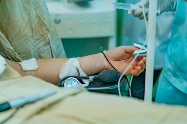 bir doktor bir şırınga hastanın operasyon öncesi anestezi için elinde tutar. Yakın çekim