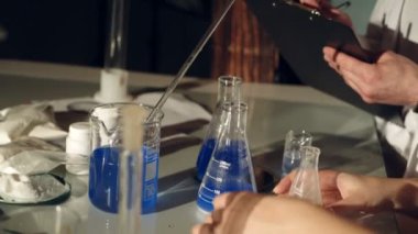 Kadehler sıvılarda inceleyerek bilim adamları. Kimya laboratuarında deneyler. Yakın çekim