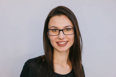 beyaz bir arka plan üzerinde gözlüklü genç esmer gülümseyen. Yakın çekim