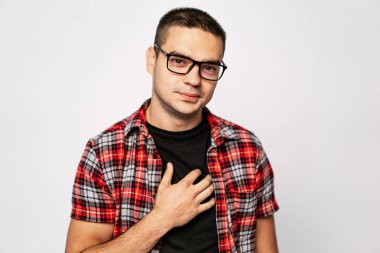 Genç adam bir çerçeve ile şık gözlük Studio beyaz bir arka plan üzerinde siyah T-shirt üzerinde elini tutar. Yakın çekim