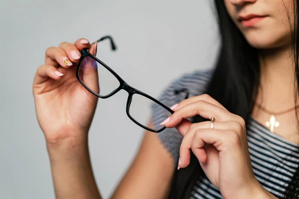 stylish glasses with black rim for office work are in the hands of a woman on a white background. Close-up